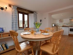 a kitchen and dining room with a wooden table and chairs at 2 Bed in Bude oc-coryw in Morwenstow +16 photos