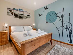 a bedroom with a bed with birds on the wall at 4 Bed in Newquay oc-56747 in Cubert