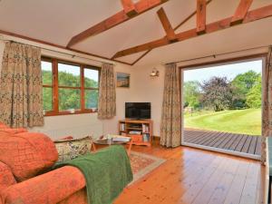 a living room with a couch and a sliding glass door at 1 Bed in Liskeard oc-nutha in Warleggan