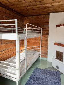 two bunk beds in a room with wooden walls at Ahtelan torppa 2 in Salo