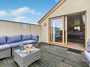 a living room with a couch and a table at 4 Bed in Newquay oc-56747 in Cubert