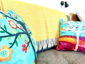 a couch with two colorful pillows on it at 1 Bed in Bude oc-88497 in Morwenstow