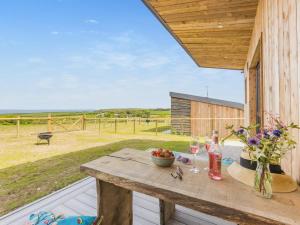 a wooden table on a deck with a view of a field at 1 Bed in Bude oc-88497 in Morwenstow