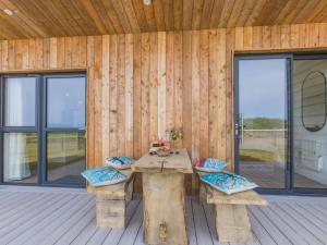 a wooden cabin with a table and chairs on a deck at 1 Bed in Bude oc-88497 in Morwenstow