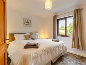 a bedroom with a large white bed with a window at 4 Bed in Bodmin oc-88543 in Bodmin