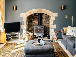 a living room with a stone fireplace and a couch at 8 Bed in Newquay oc-81510 in Saint Columb Major