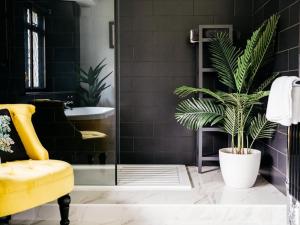 a bathroom with a yellow chair and a plant at 8 Bed in Newquay oc-81510 in Saint Columb Major +40 photos