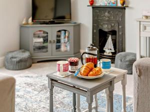 a table with a plate of croissants on it in a living room at 2 Bed in Looe oc-82537 in Looe +15 photos