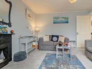 a living room with a couch and a fireplace at 2 Bed in Looe oc-82537 in Looe