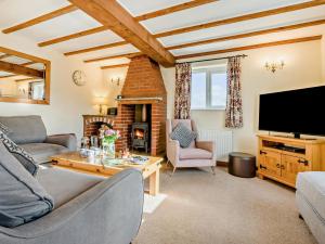 a living room with a fireplace and a tv at 3 Bed in Padstow oc-treba in Saint Merryn