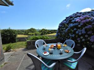 a blue table and chairs with food and drinks at 2 Bed in Falmouth oc-tvean in Constantine