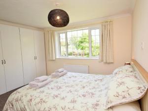 a bedroom with a large bed and a window at 2 Bed in Wadebridge oc-51925 in Egloshayle