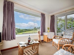 a child standing in front of a window in a living room at 2 Bed in Falmouth oc-tvean in Constantine