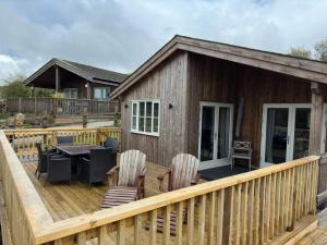 a wooden deck with chairs and a table and a house at 3 Bed in St. Columb oc-43079 in Saint Columb Major