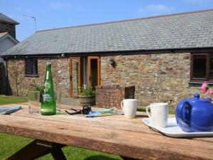 a wooden table with a bottle and cups on it at 2 Bed in Bude oc-coryb in Morwenstow +15 photos