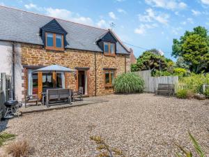 a stone house with a patio and a fence at 3 Bed in Bridport oc-dc049 in Chideock