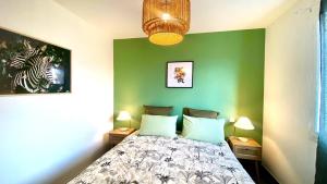 a bedroom with a bed and a green wall at Casa Amarante - Piscine privée chauffée - Climatisation - WIFI in Roquefort-des-Corbières