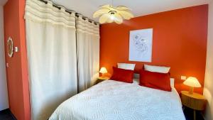 a bedroom with orange walls and a bed with red pillows at Casa Amarante - Piscine privée chauffée - Climatisation - WIFI in Roquefort-des-Corbières