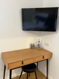 a wooden desk with a television on a wall at Hotel Bastei in Mühldorf