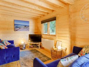 a living room with blue couches and a television at 2 Bed in Holsworthy oc-87766 in Week Saint Mary