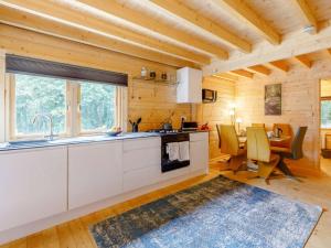 a kitchen with white cabinets and a dining table at 2 Bed in Holsworthy oc-87766 in Week Saint Mary