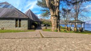 a house with a gazebo next to a lake at MAC Skyline Lodges in Balloch