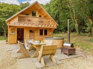 a wooden cabin with a picnic table and a hot tub at 2 Bed in Holsworthy oc-87766 in Week Saint Mary