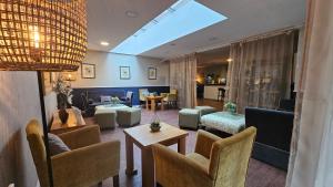 a living room with couches and chairs and a skylight at Muthu Clumber Park Hotel and Spa in Worksop
