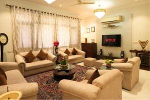 a large living room with couches and a tv at Palm 34 in Jaipur