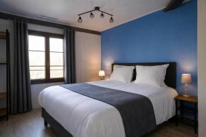 a bedroom with a large bed with a blue wall at le saint Hubert in Arcis-sur-Aube
