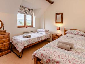 a bedroom with two beds and a window at 3 Bed in Bridport oc-dc087 in Chideock