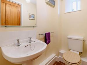 a bathroom with a white sink and a toilet at 3 Bed in Bridport oc-dc087 in Chideock +23 photos