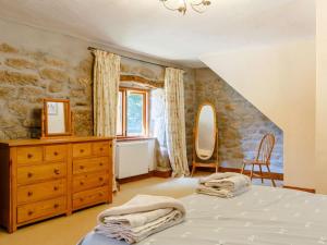 a bedroom with a bed and a dresser and a mirror at 2 Bed in Bodmin oc-chest in Lanlivery