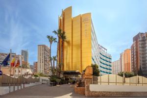 a yellow building in the middle of a city at Hotel Servigroup Rialto in Benidorm