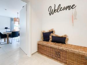 a living room with a couch and a welcome sign on the wall at Hygge Hus 1 in Timmendorfer Strand