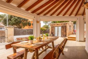 an outdoor dining room with a wooden table and chairs at Villa Rincon by Villa Plus in Cala Blanca