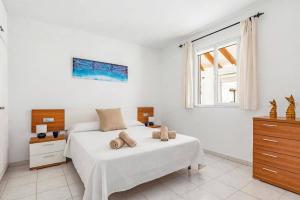 a white bedroom with a bed and a window at Villa Rincon by Villa Plus in Cala Blanca +12 photos