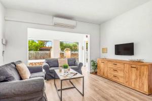 a living room with a couch and a tv at Villa Rincon by Villa Plus in Cala Blanca