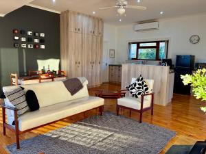a living room with a couch and two chairs at Emmie's Cottage in Rietvlei Number 1 +13 photos