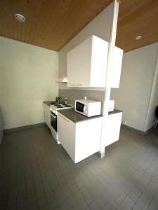 a kitchen with white cabinets and a stove at Ahtelan torppa 2 in Salo