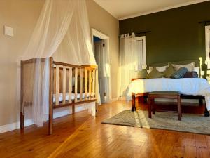 a bedroom with a bed and a crib in it at Emmie's Cottage in Rietvlei Number 1