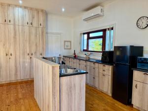 a kitchen with a sink and a black refrigerator at Emmie's Cottage in Rietvlei Number 1