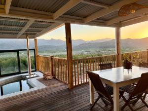 a deck with a table and chairs and a view of mountains at Emmie's Cottage in Rietvlei Number 1