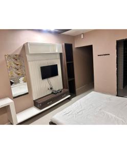 a bedroom with a bed and a flat screen tv at The Golden Wings Hotel in Dewās