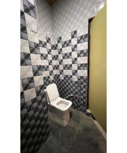 a small bathroom with a toilet in a stall at The Golden Wings Hotel in Dewās