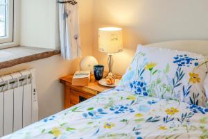 a bedroom with a bed with a blue and white comforter at 1 Bed in Winskill oc-c36298 in Little Salkeld +7 photos