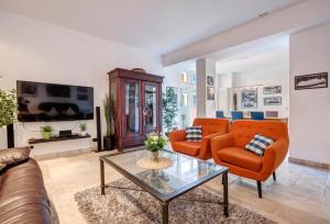 ein Wohnzimmer mit orangefarbenen Stühlen und einem Glastisch in der Unterkunft Residenz Bellevue in Bansin