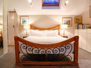 a bedroom with a large wooden bed with white sheets at Ty Uchaf in Colwyn Bay