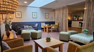 a living room with couches and tables and chairs at Muthu Clumber Park Hotel and Spa in Worksop +100 photos