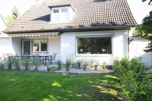 a white house with a table and chairs in a yard at Bootshaus in Timmendorfer Strand